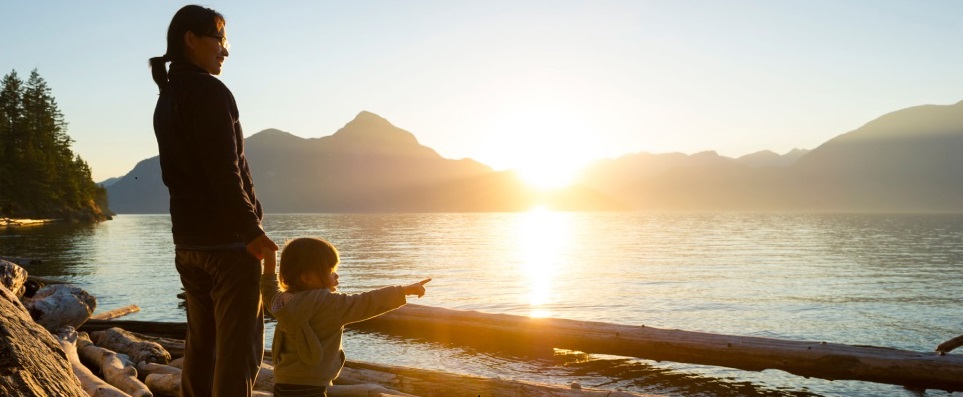 Women holding hand with child at lake